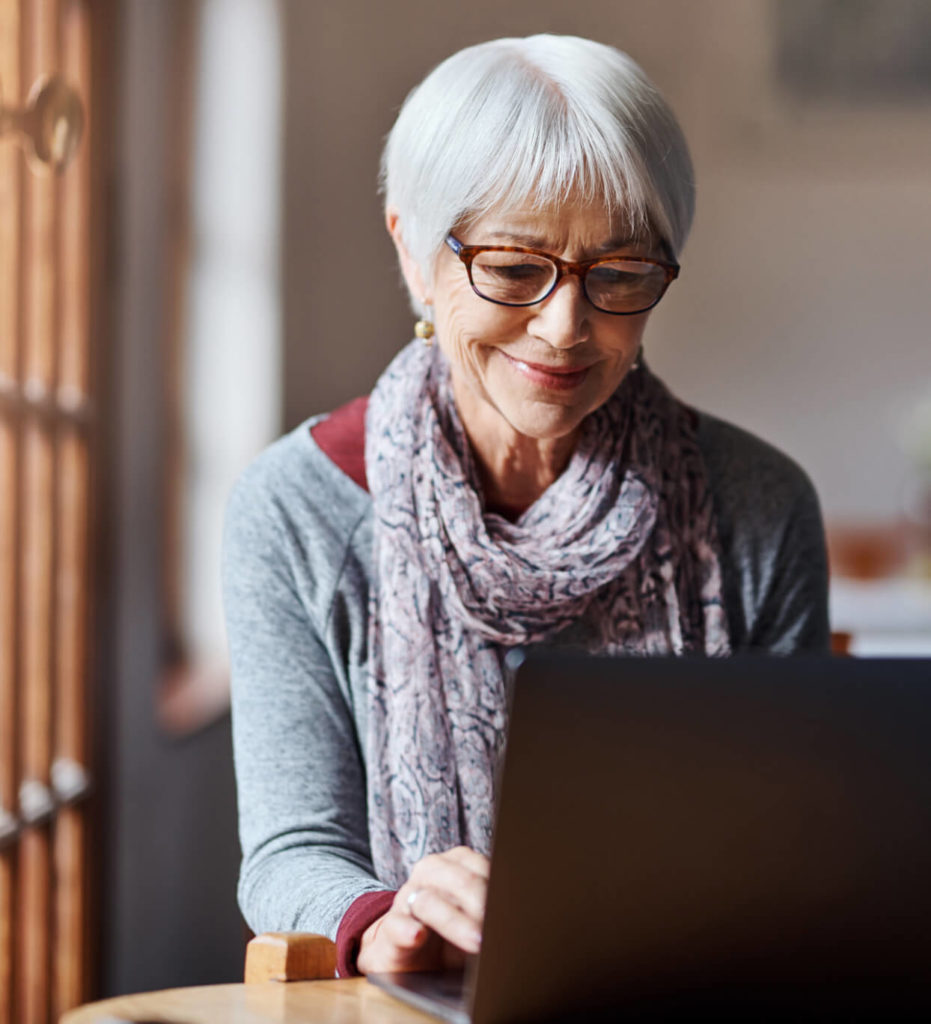 Woman sitting at computer using Hometown Health Clinic Telehealth