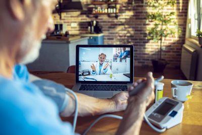 Close up of a senior man consulting with a doctor on his laptop